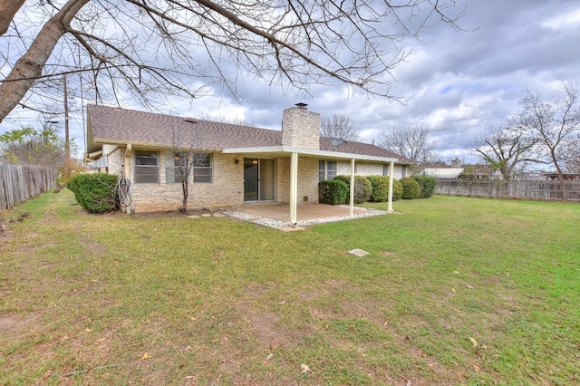 rear view of house featuring a lawn and a patio