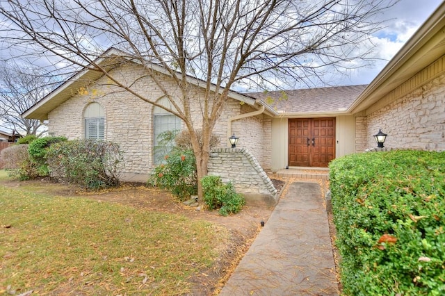 view of exterior entry featuring a yard