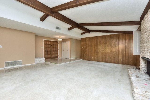 unfurnished living room with carpet, vaulted ceiling with beams, a fireplace, and wooden walls