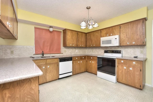 kitchen featuring sink, an inviting chandelier, a textured ceiling, decorative light fixtures, and white appliances