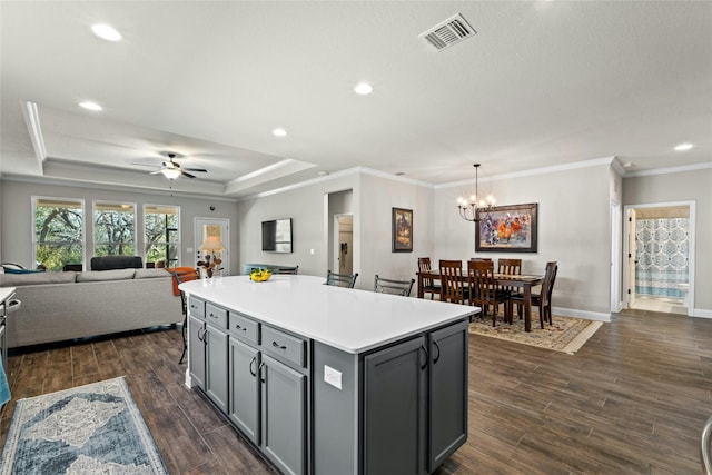 kitchen with a center island, pendant lighting, light countertops, gray cabinetry, and open floor plan