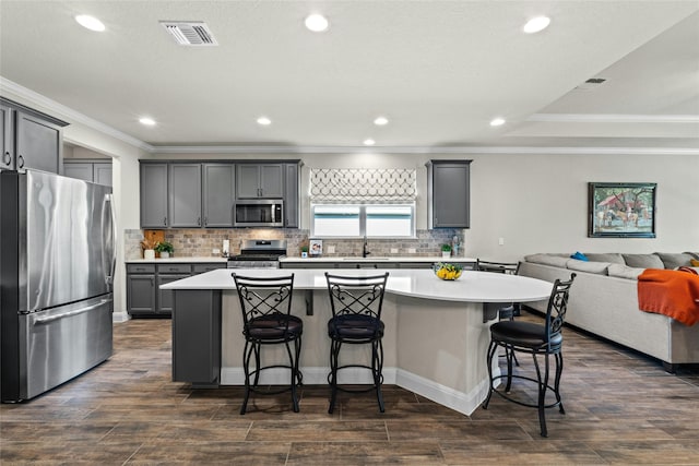 kitchen featuring visible vents, open floor plan, light countertops, appliances with stainless steel finishes, and a large island