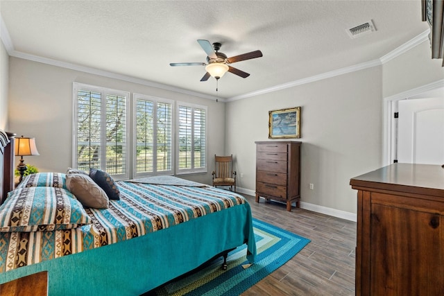 bedroom with visible vents, ornamental molding, a textured ceiling, wood finished floors, and baseboards