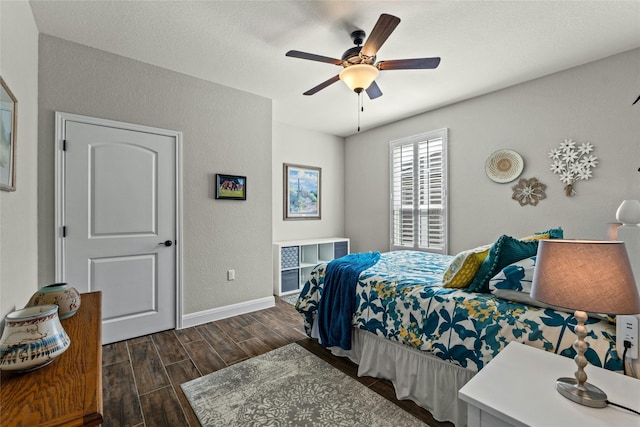 bedroom with ceiling fan, dark wood-style flooring, and baseboards