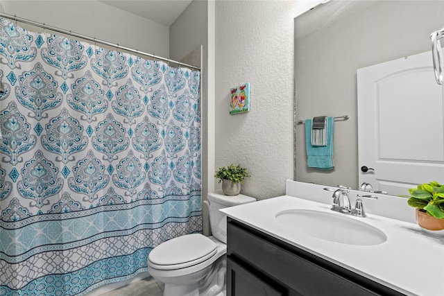 full bathroom with a shower with curtain, a textured wall, vanity, and toilet