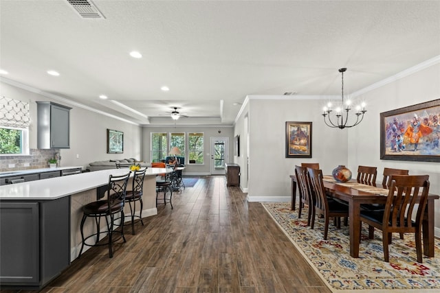 dining area featuring dark wood-style floors, a wealth of natural light, visible vents, and crown molding