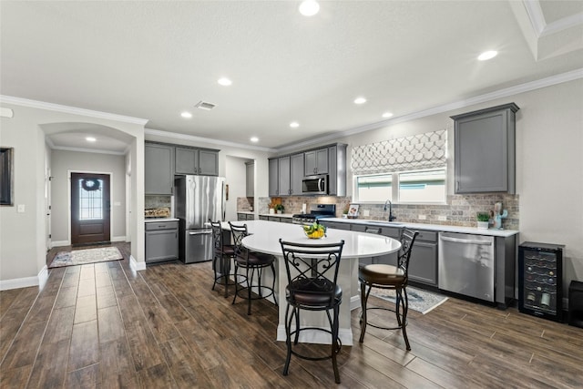 kitchen with a kitchen breakfast bar, stainless steel appliances, light countertops, and a center island