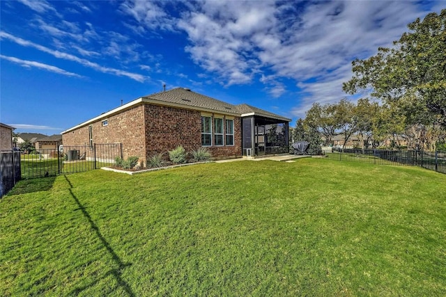 back of property featuring a yard, brick siding, a patio, and a fenced backyard