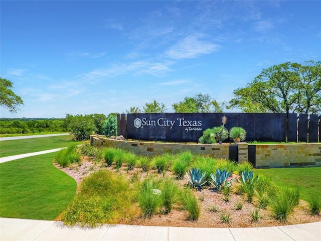 community sign featuring a lawn