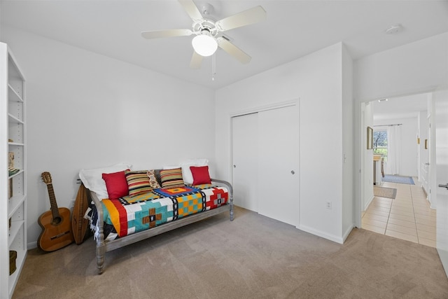 carpeted bedroom with ceiling fan and a closet