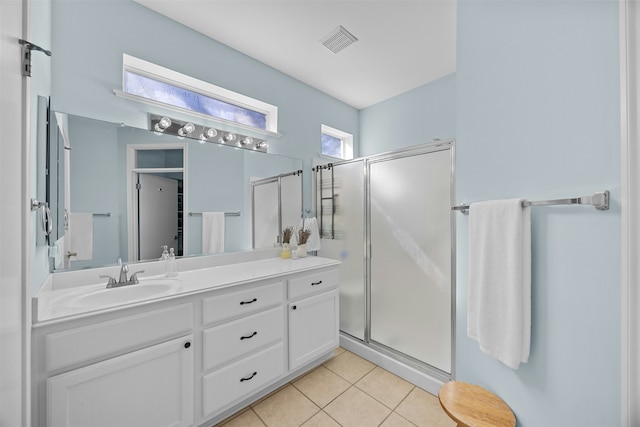 bathroom featuring tile patterned flooring, a shower with shower door, and vanity