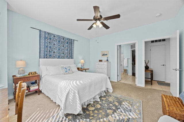 carpeted bedroom with ceiling fan and ensuite bath