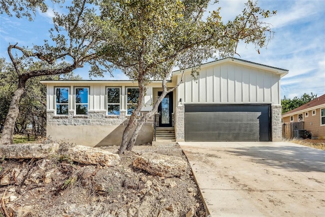 single story home with central AC unit and a garage