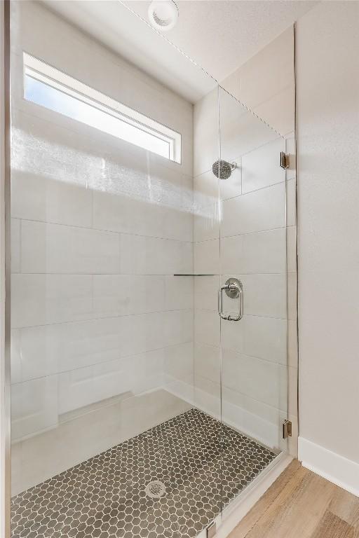 bathroom featuring an enclosed shower and hardwood / wood-style flooring