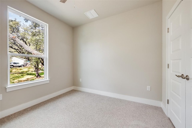 carpeted spare room featuring plenty of natural light