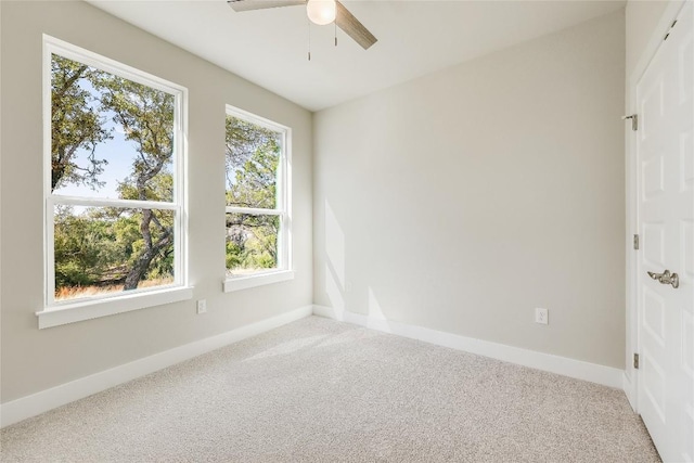 unfurnished room with light colored carpet, ceiling fan, and a healthy amount of sunlight