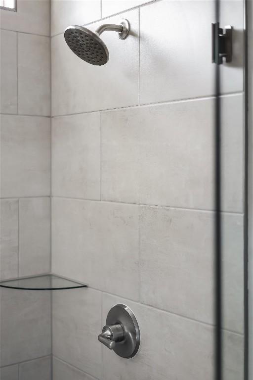 interior details featuring a tile shower