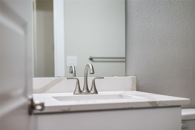 interior details featuring vanity and toilet