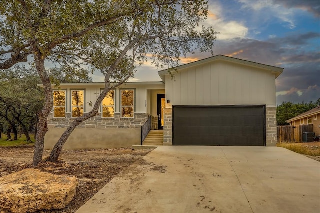 single story home featuring cooling unit and a garage