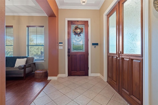 entrance foyer with ornamental molding and light tile patterned floors