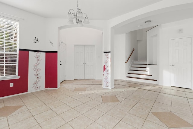 tiled entryway featuring an inviting chandelier