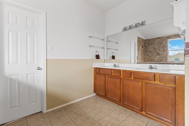 full bathroom with double vanity, a sink, and tile patterned floors