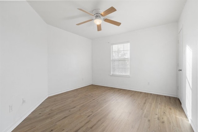 unfurnished room featuring a ceiling fan, light wood-type flooring, and baseboards