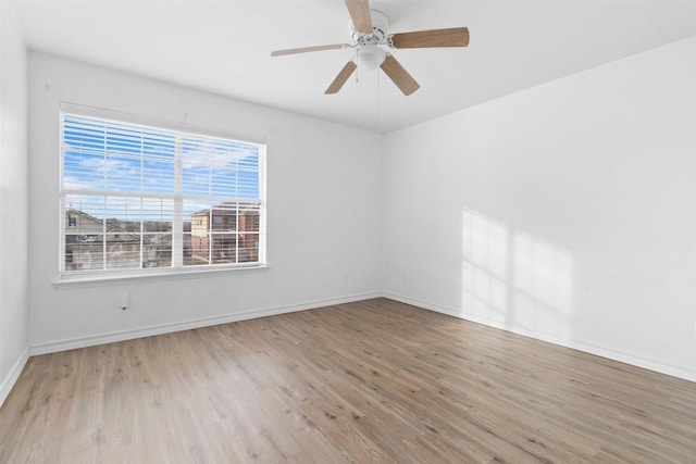 empty room with baseboards, ceiling fan, and light wood finished floors