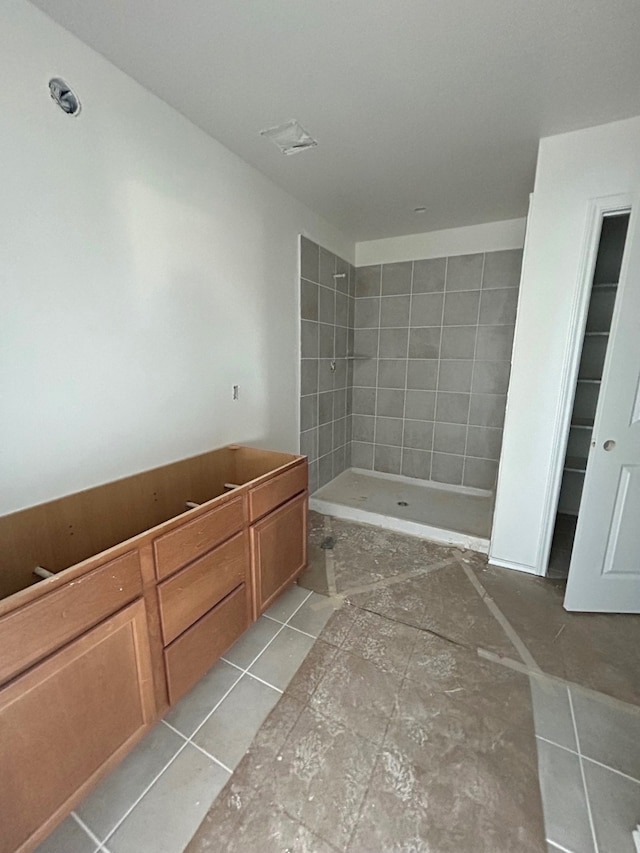 bathroom featuring tile patterned flooring and a tile shower