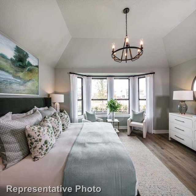 bedroom with wood-type flooring, vaulted ceiling, and an inviting chandelier