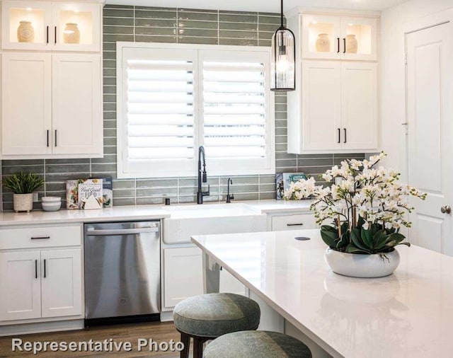 kitchen with dishwasher, decorative backsplash, white cabinetry, and hanging light fixtures