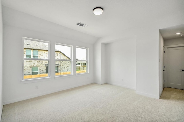 carpeted spare room featuring baseboards and visible vents