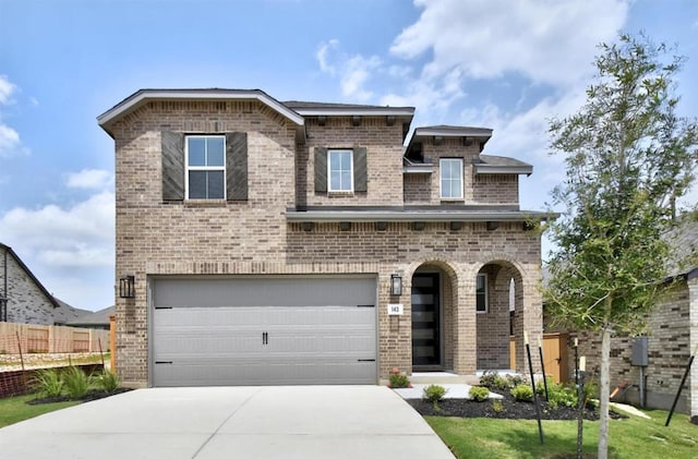 view of front of house with a garage, fence, driveway, and brick siding