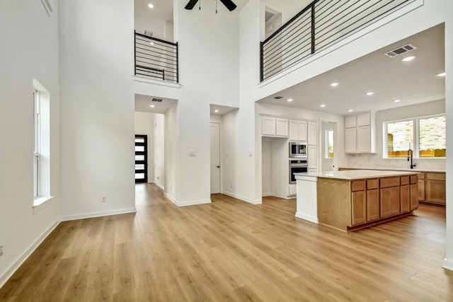 kitchen with visible vents, light countertops, a ceiling fan, light wood finished floors, and stainless steel appliances