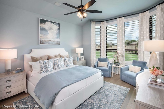 bedroom featuring ceiling fan, hardwood / wood-style floors, and vaulted ceiling