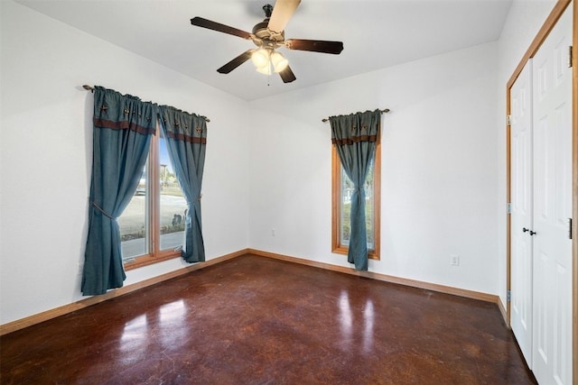 empty room with ceiling fan and concrete floors