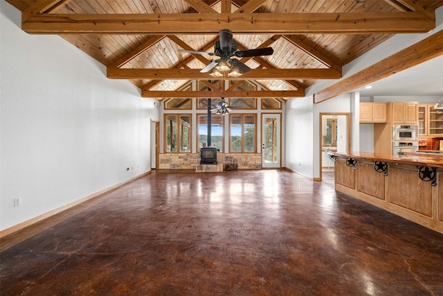 unfurnished living room featuring beam ceiling, a wood stove, high vaulted ceiling, and wooden ceiling