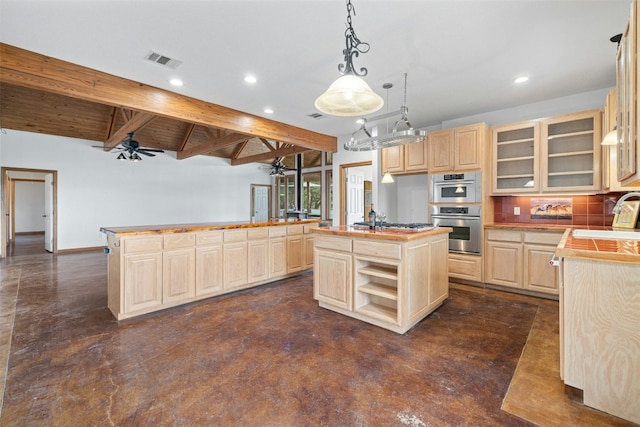 kitchen featuring light brown cabinets, tasteful backsplash, double oven, and an island with sink