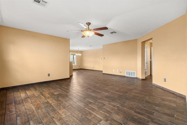 unfurnished room featuring ceiling fan with notable chandelier