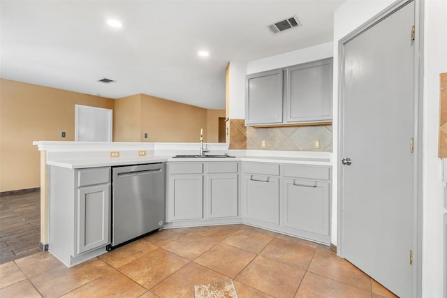 kitchen with decorative backsplash, kitchen peninsula, gray cabinetry, sink, and dishwasher