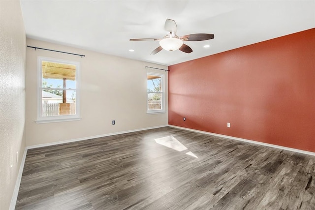 spare room featuring dark hardwood / wood-style flooring, plenty of natural light, and ceiling fan