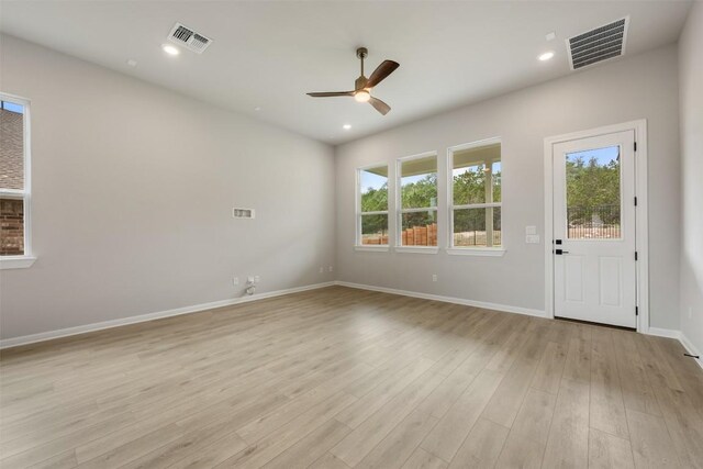 spare room with ceiling fan, light wood-style flooring, baseboards, and visible vents