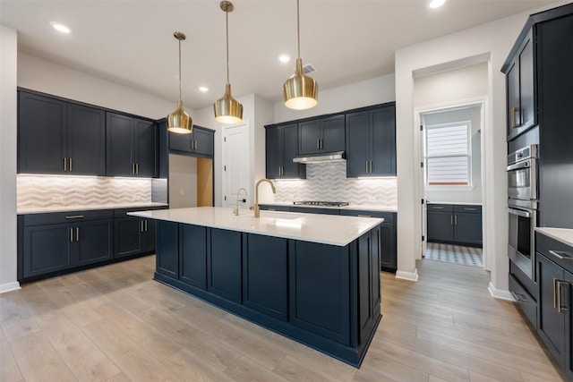 kitchen with light wood finished floors, tasteful backsplash, and light countertops