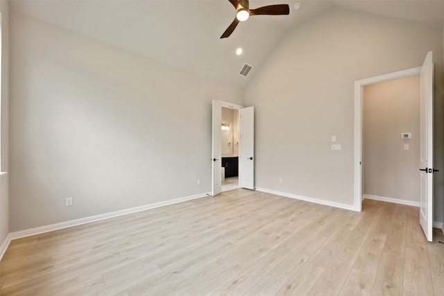 unfurnished bedroom with high vaulted ceiling, ensuite bathroom, light wood-type flooring, and baseboards