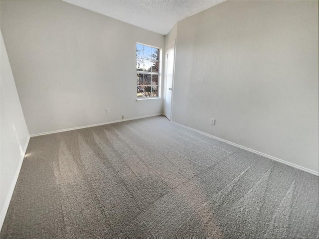 carpeted empty room with a textured ceiling