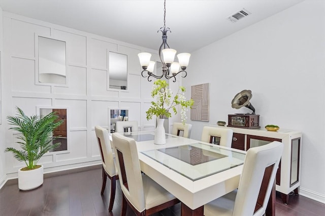 dining space with dark wood-type flooring and a chandelier