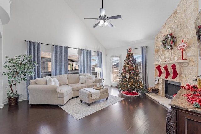 living room with a stone fireplace, ceiling fan, high vaulted ceiling, and dark wood-type flooring