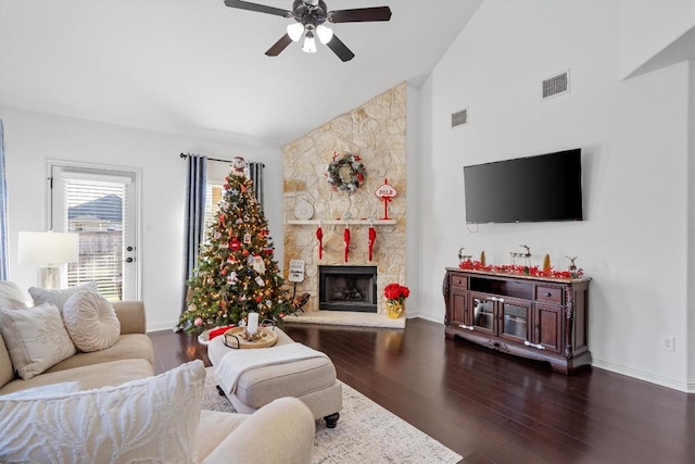 living room featuring ceiling fan, dark hardwood / wood-style flooring, a fireplace, and vaulted ceiling