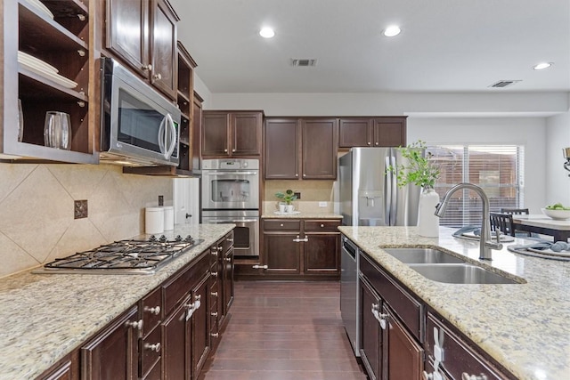 kitchen with dark brown cabinetry, sink, stainless steel appliances, and dark hardwood / wood-style floors