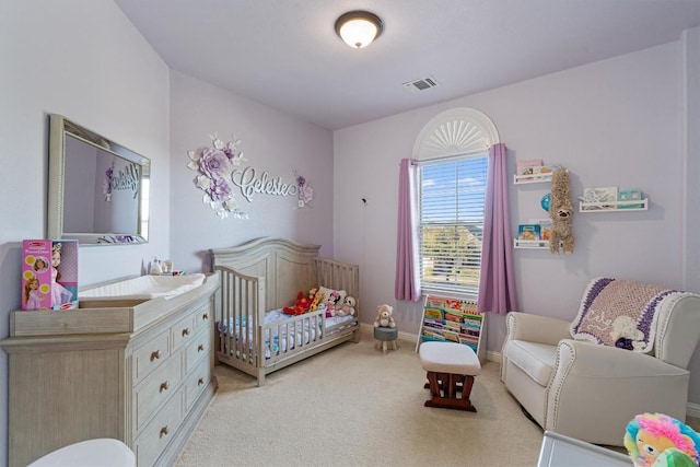 bedroom featuring a crib and light carpet